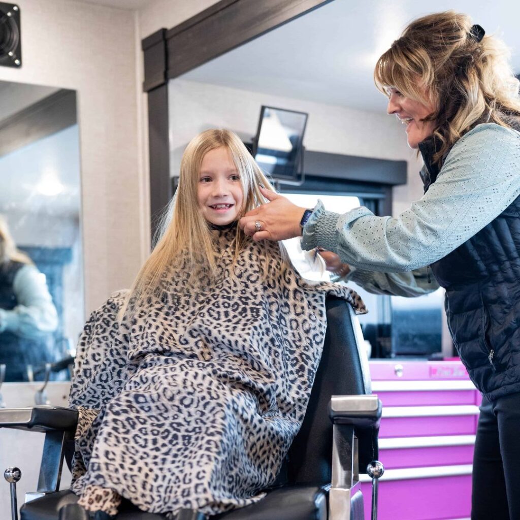 Amber Owen cutting young girl's hair