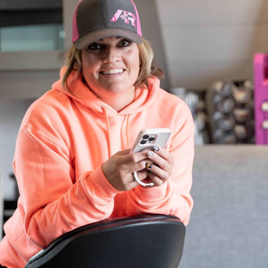 woman holding phone smiling at camera