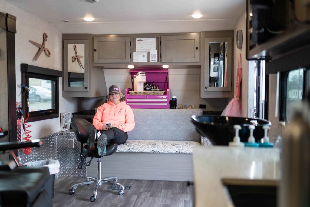 woman inside mobile hair salon trailer