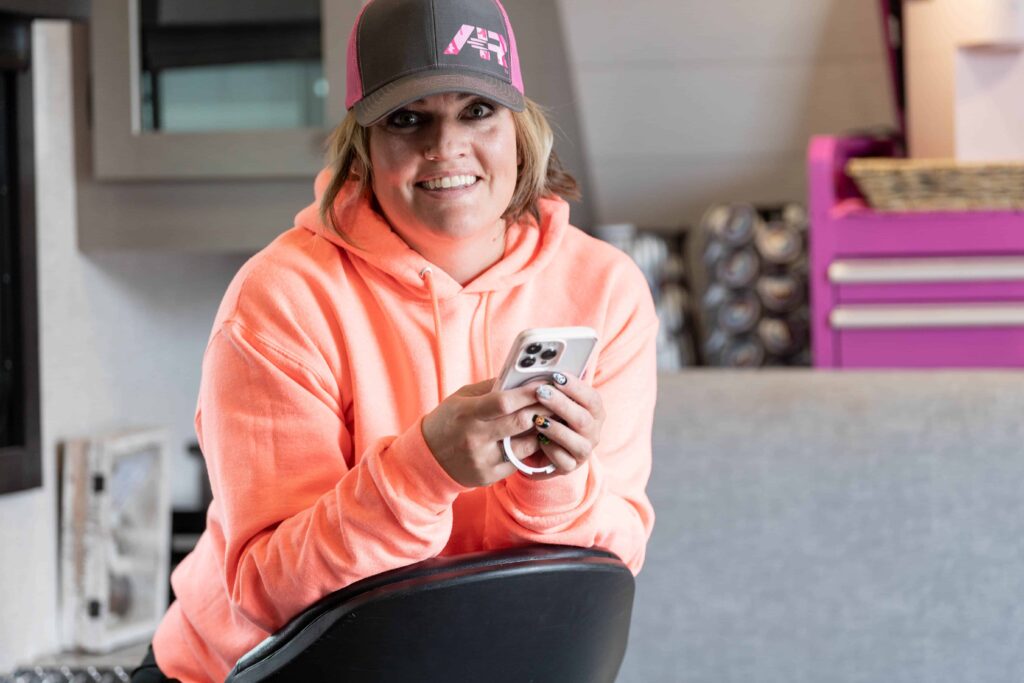 woman holding phone smiling at camera